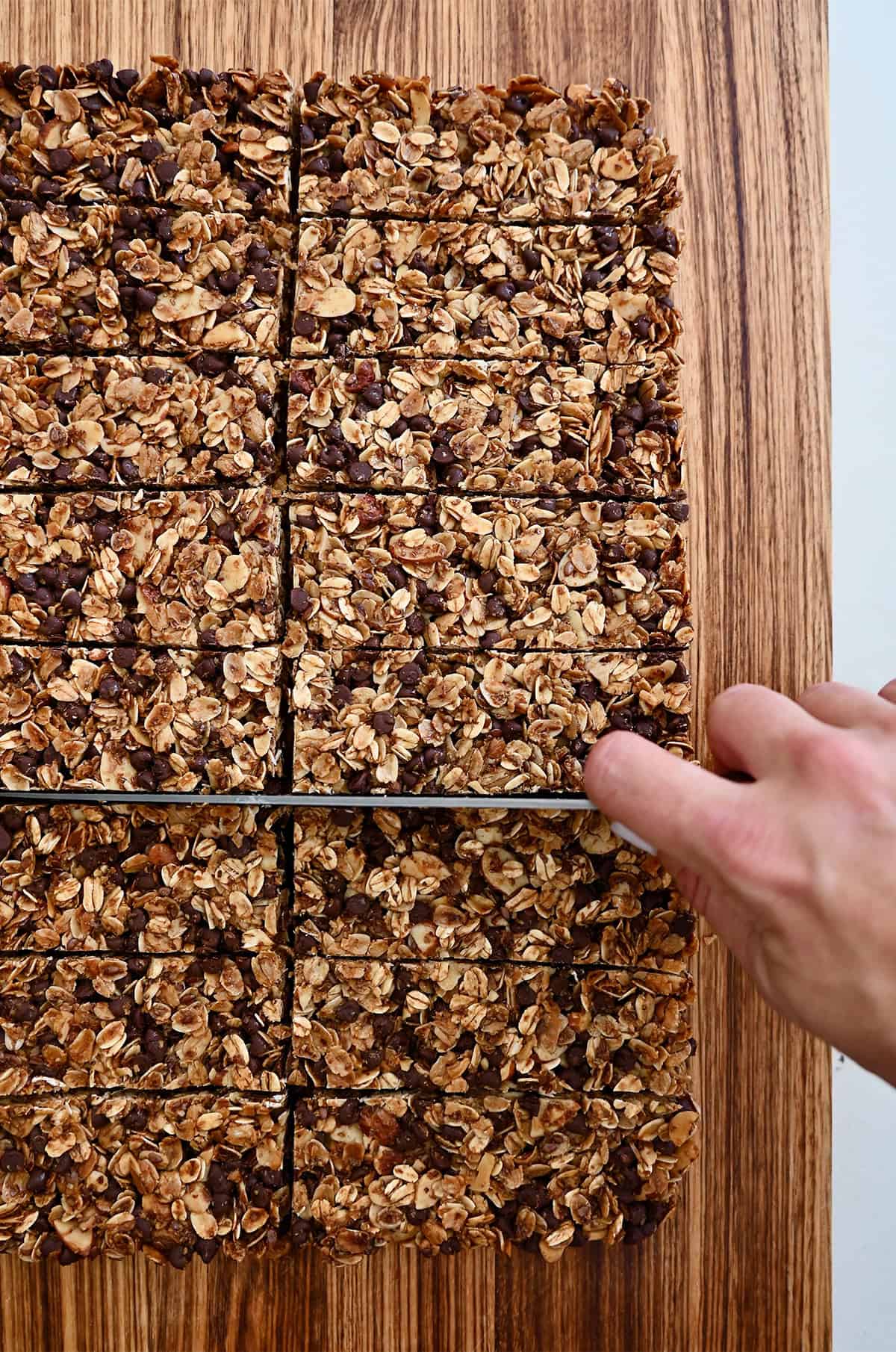 Cutting a slab of chocolate chip granola into bars.