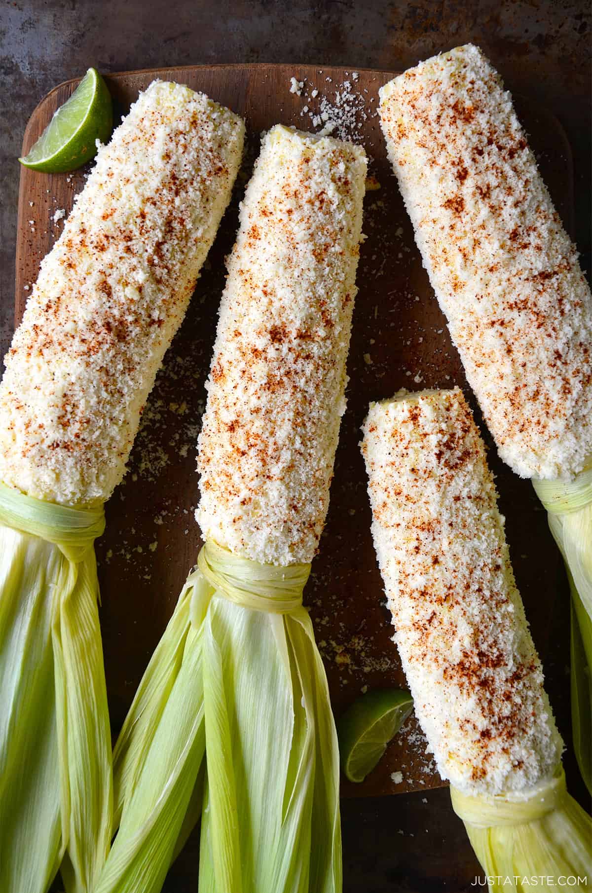 Four elotes or Mexican street corn, which is corn on the cob slathered with a mixture of mayo, Mexican crema and lime juice then rolled in Cotija cheese and sprinkled with chili powder.