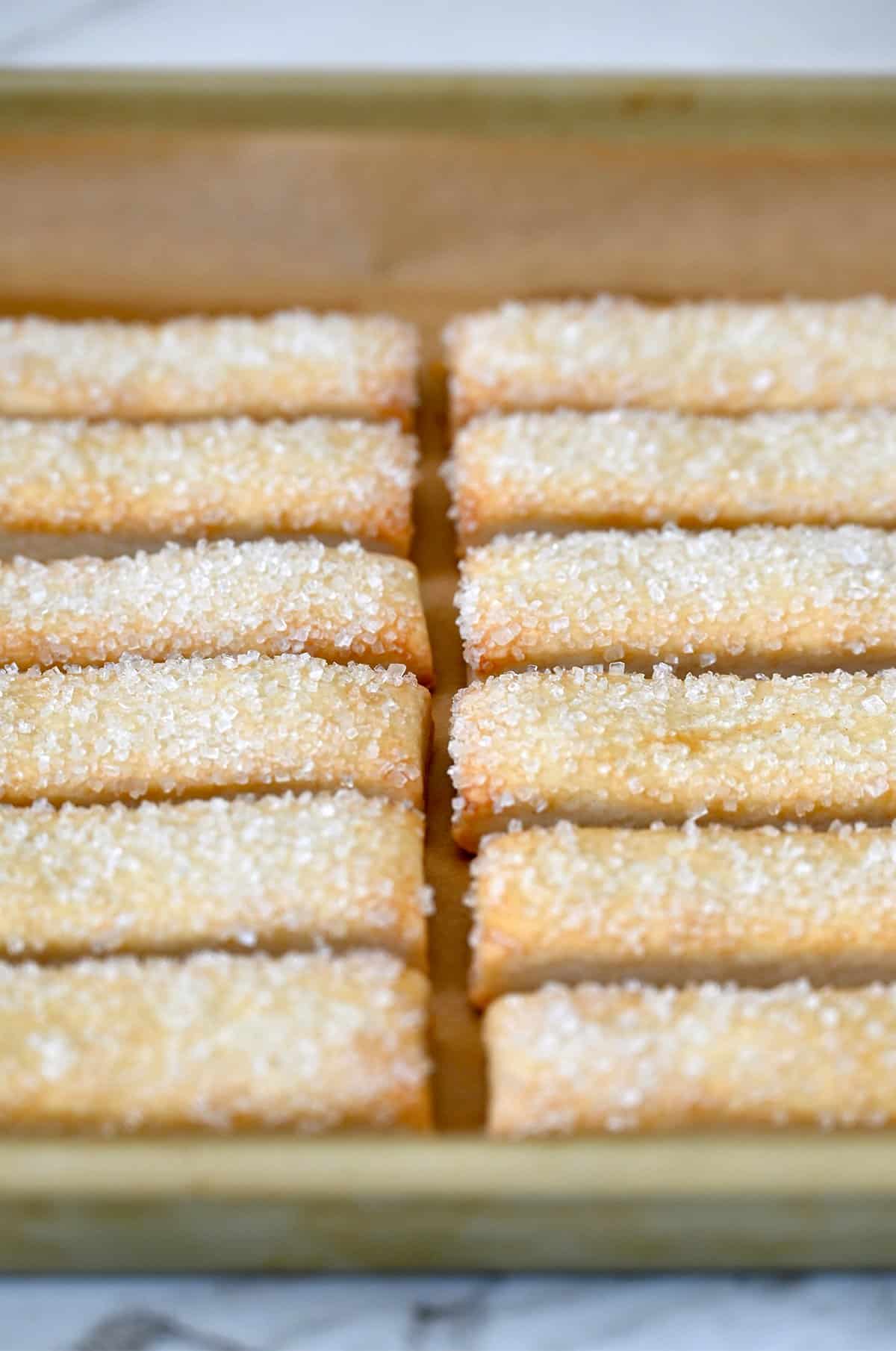 Golden brown pie cookies on a parchment paper-lined baking sheet.