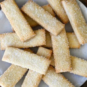 Pie crust cookies topped with sanding sugar on a white platter.