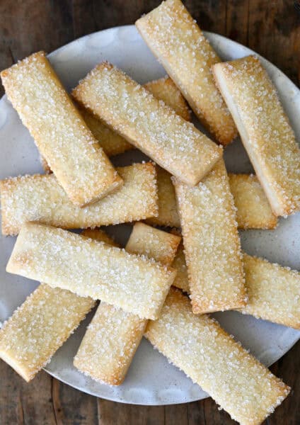 Pie crust cookies topped with sanding sugar on a white platter.
