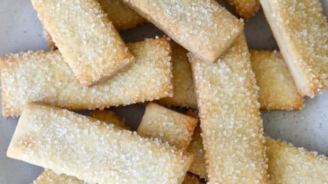 Pie crust cookies topped with sanding sugar on a white platter.