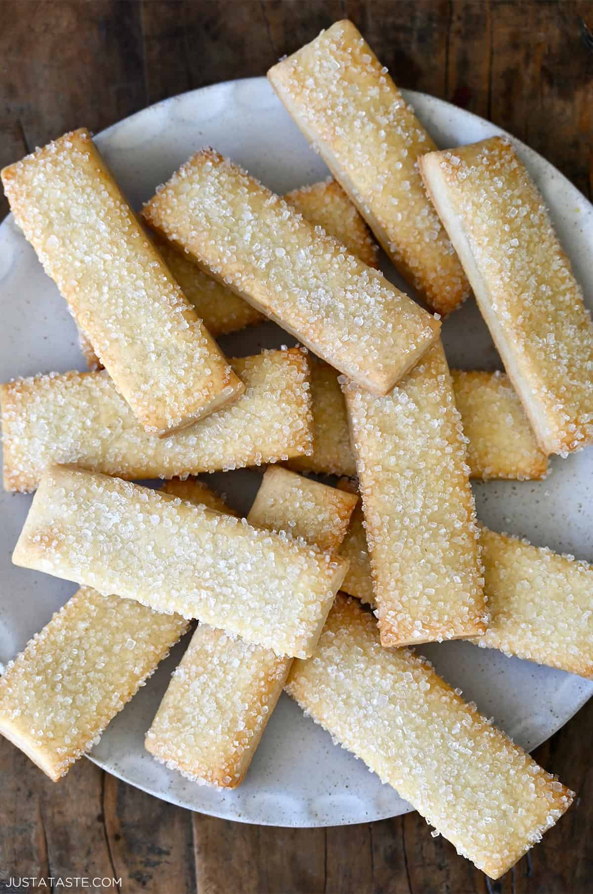Pie crust cookies topped with sanding sugar on a white platter.