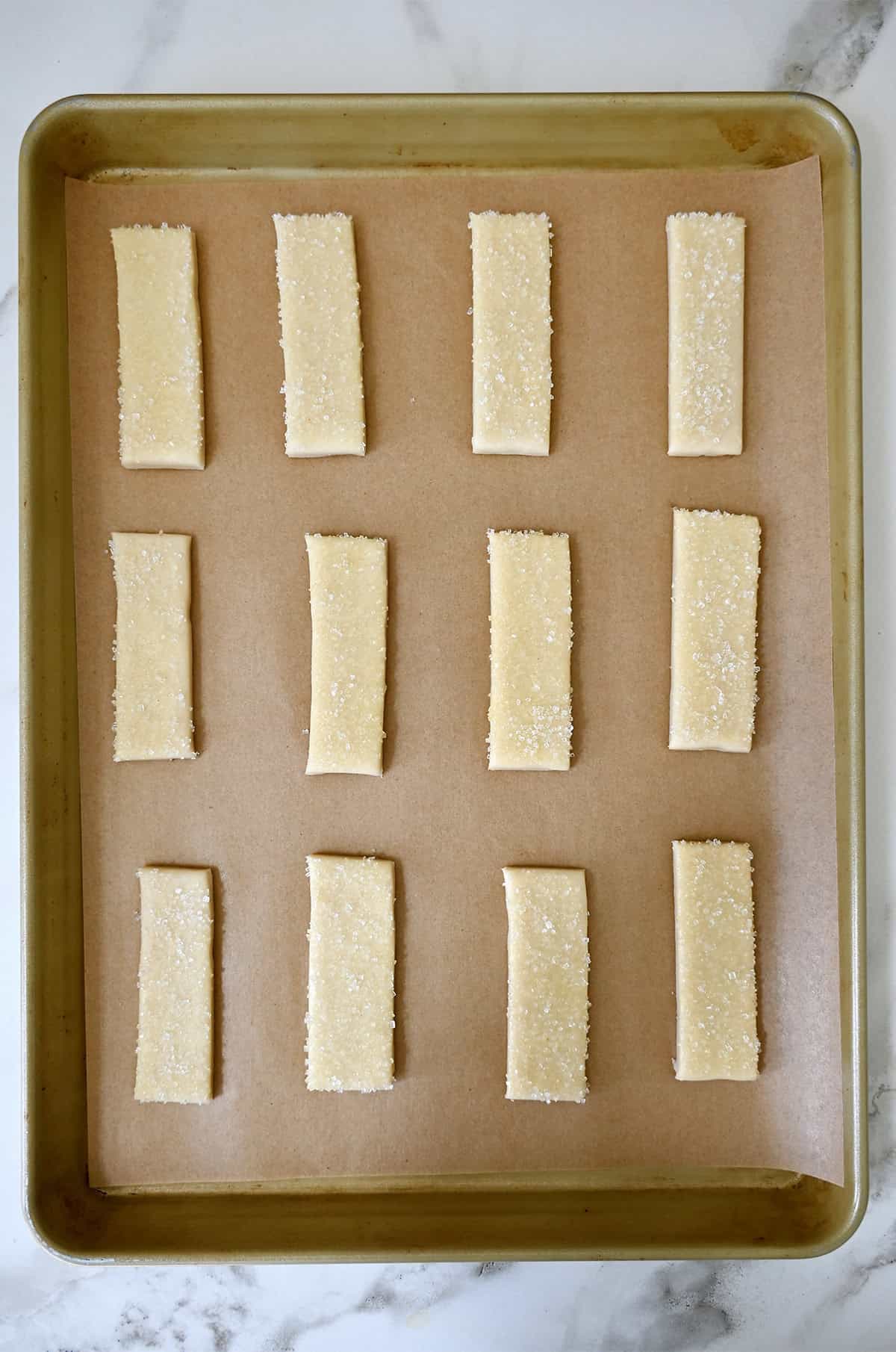 Unbaked pie cookies on a parchment paper-lined baking sheet.