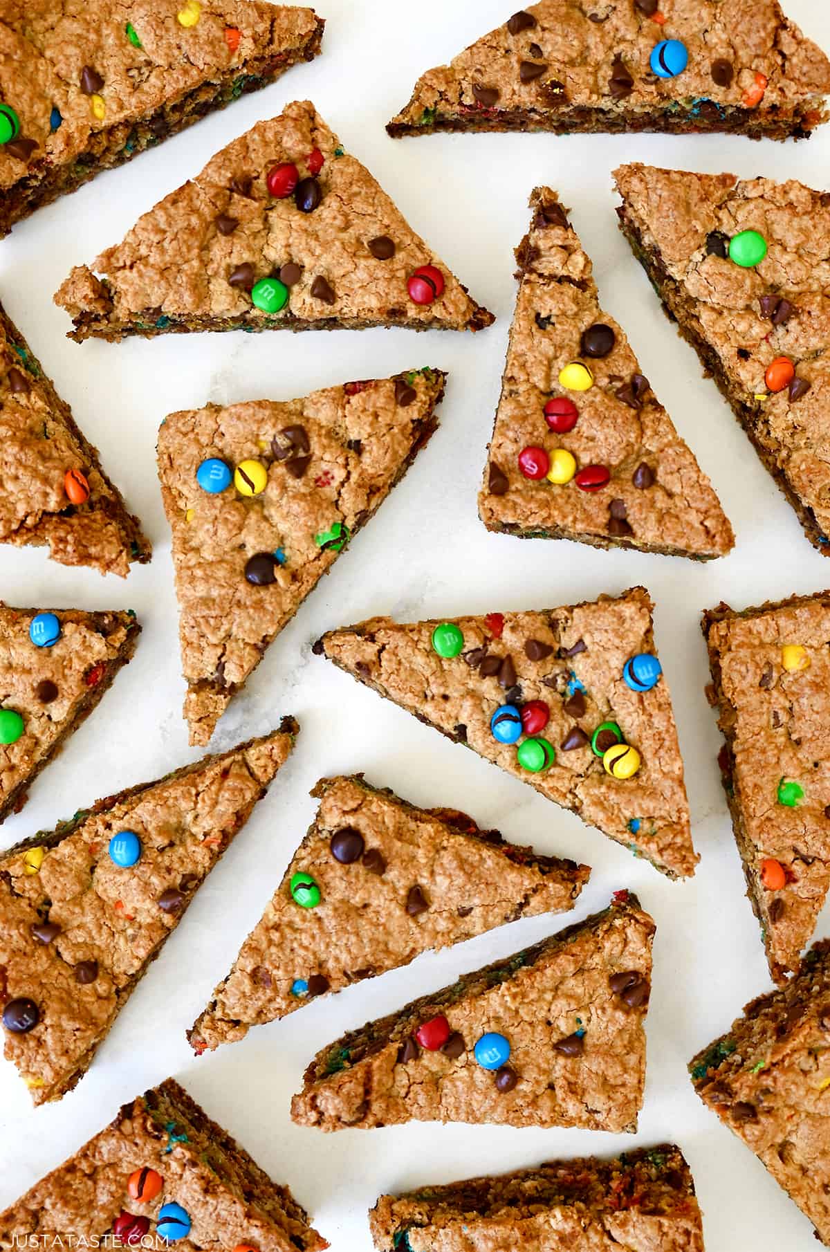 Monster cookie bars studded with M&Ms and chocolate chips cut into triangles.