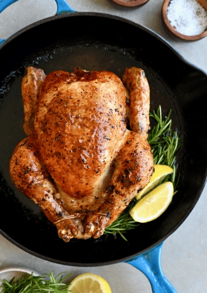 Simple roast chicken with rosemary and lemon in a cast iron skillet.
