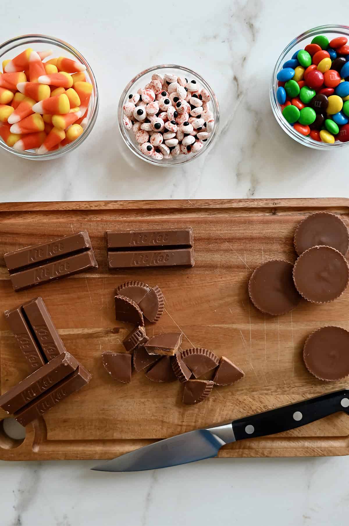 Chopping Reese's and KitKat bars into bite-sized pieces for chocolate bark.
