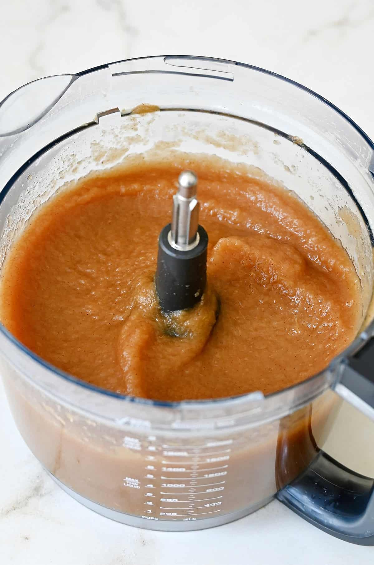 Puréed cinnamon applesauce in a food processor bowl.