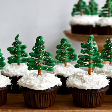 A "forest" of Chocolate Christmas Tree Cupcakes with Cream Cheese Frosting and pretzel/candy melt toppers