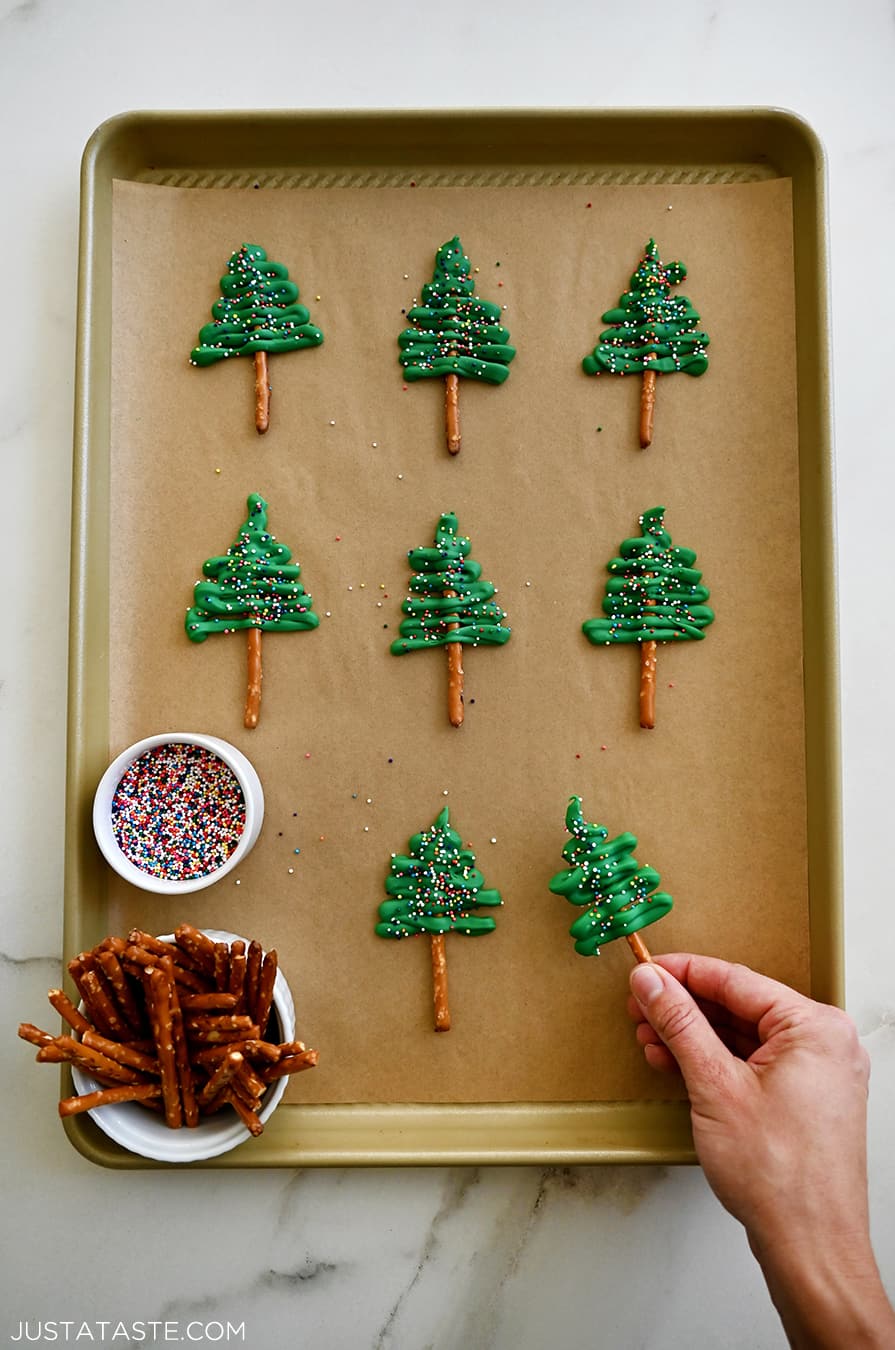 Christmas tree cupcake toppers with rainbow sprinkles on a parchment paper-lined baking sheet