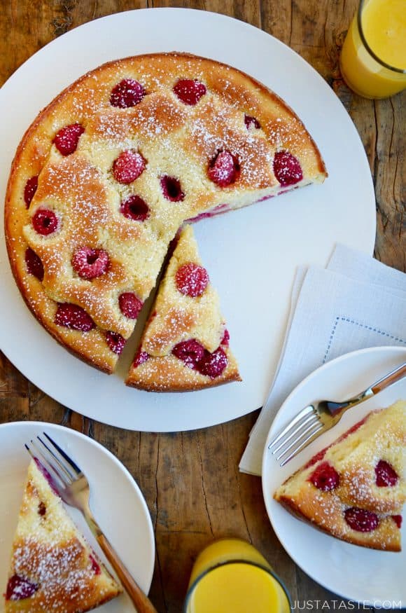 Top down view of Raspberry Cream Cheese Coffee Cake on white plate and glasses filled with orange juice
