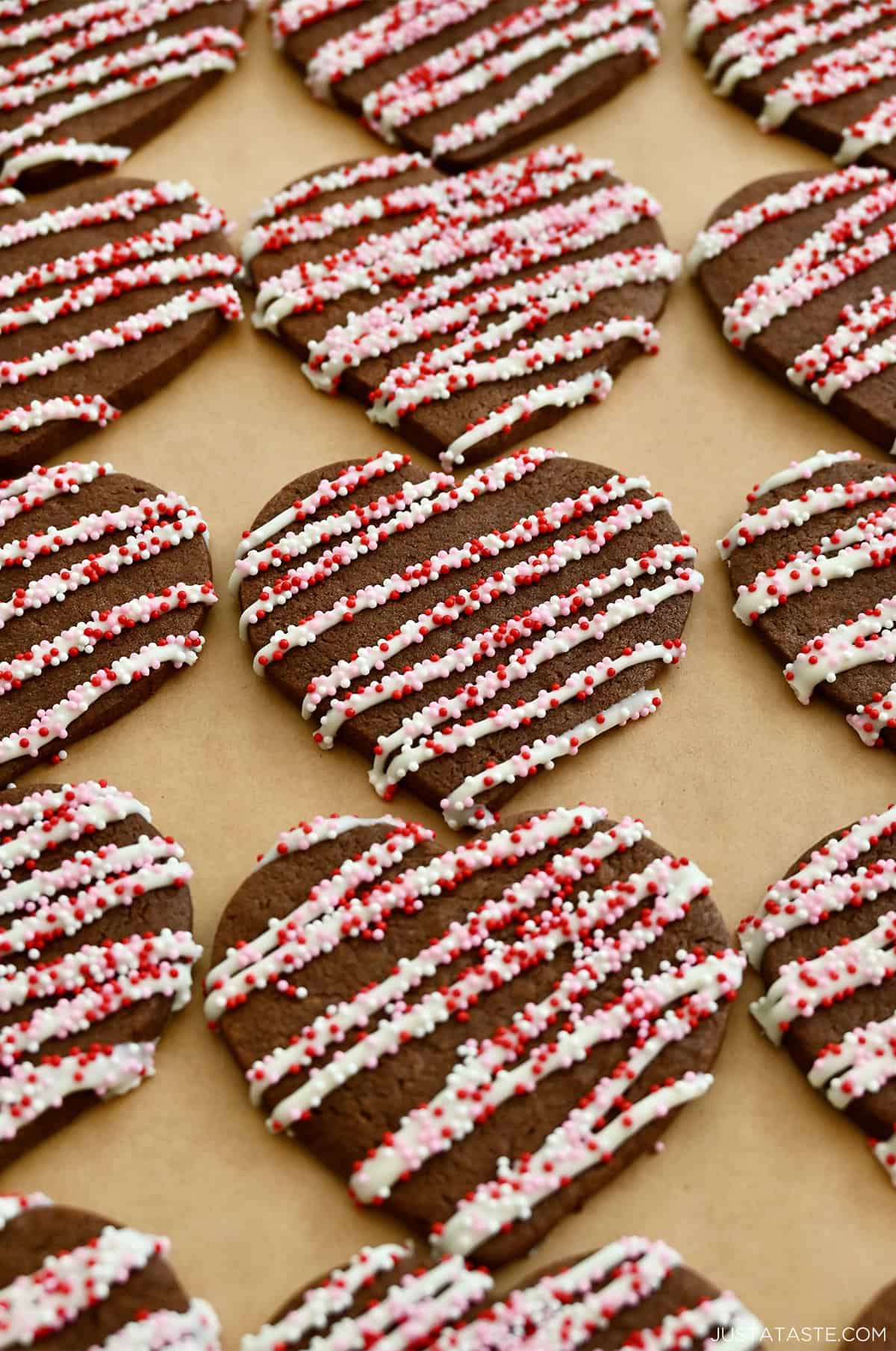 Chocolate sugar cookies with icing and red and white sprinkles.