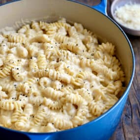 A large blue stockpot containing macaroni and cheese.