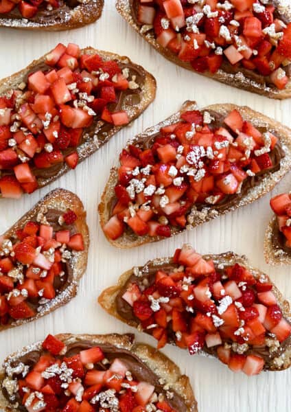 A top-down view of Strawberry Bruschetta starring Nutella, fresh strawberries and chopped walnuts