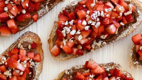 A top-down view of Strawberry Bruschetta starring Nutella, fresh strawberries and chopped walnuts