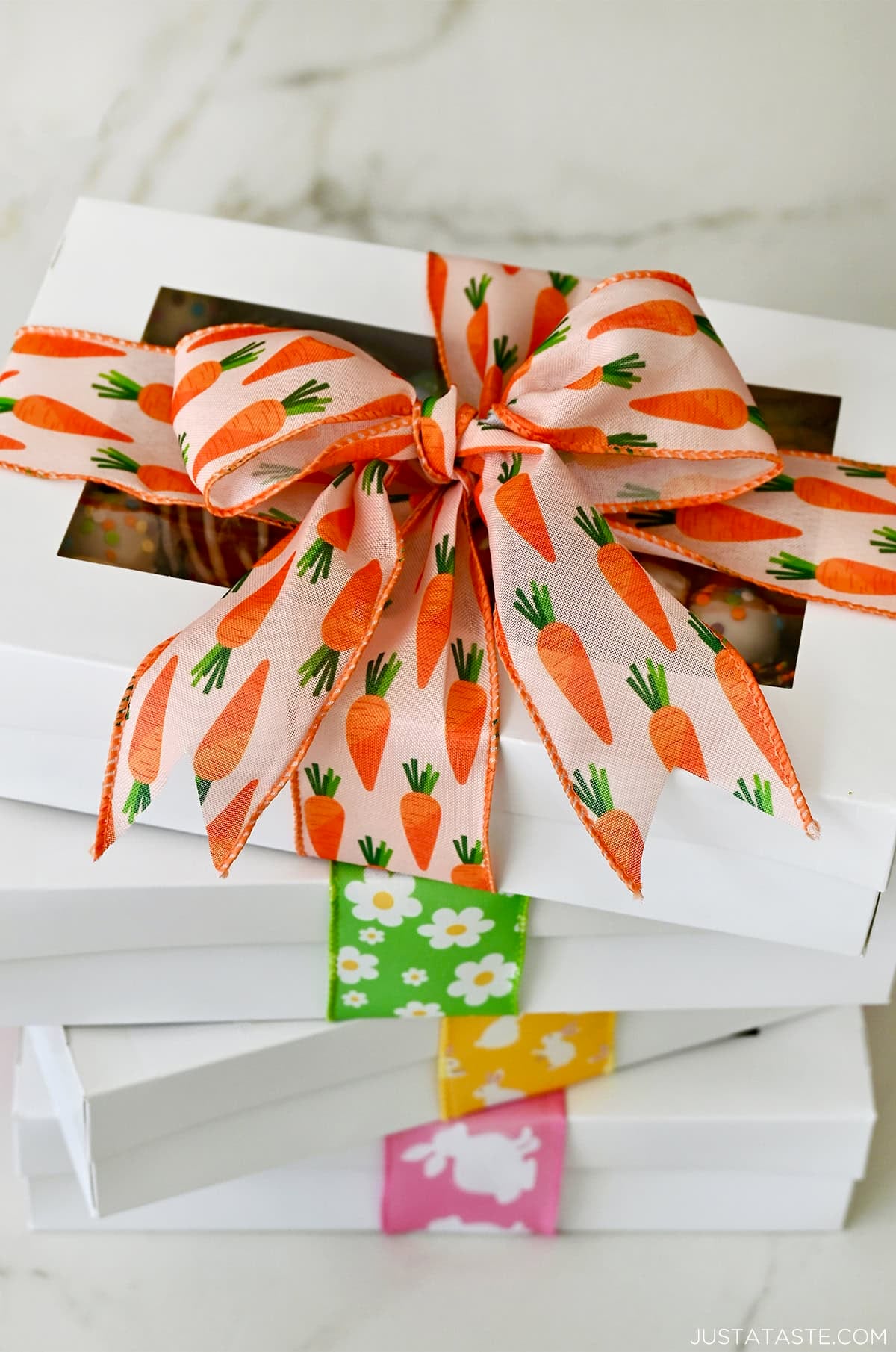 A stack of boxes filled with cookies and wrapped with spring-inspired ribbon for gifting.