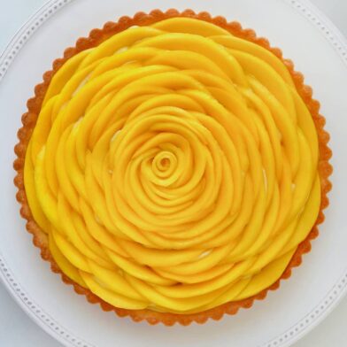 Top down view of easy mango tart with vanilla bean pastry cream on a white plate