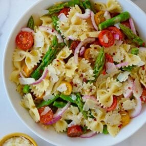 Large white bowl containing Asparagus Pasta Salad with Italian Dressing