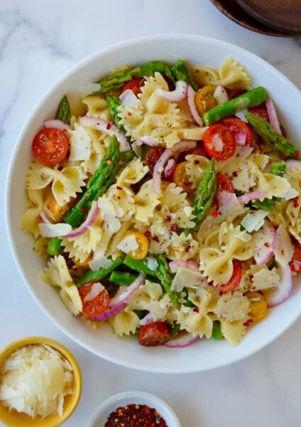 Large white bowl containing Asparagus Pasta Salad with Italian Dressing