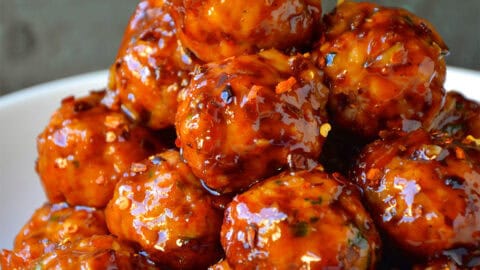 Baked orange chicken meatballs piled high in a bowl.