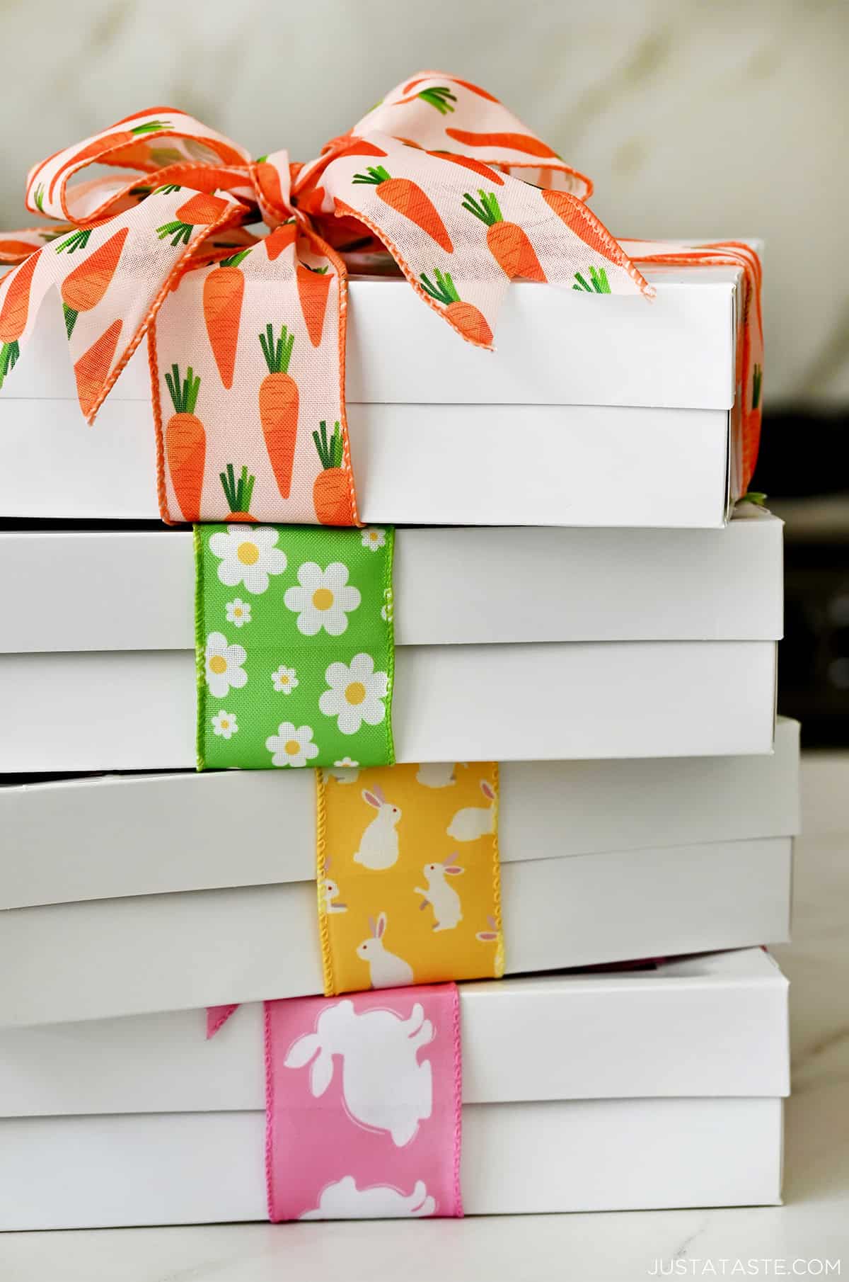 Four cookie boxes with springtime ribbon ready for gifting.