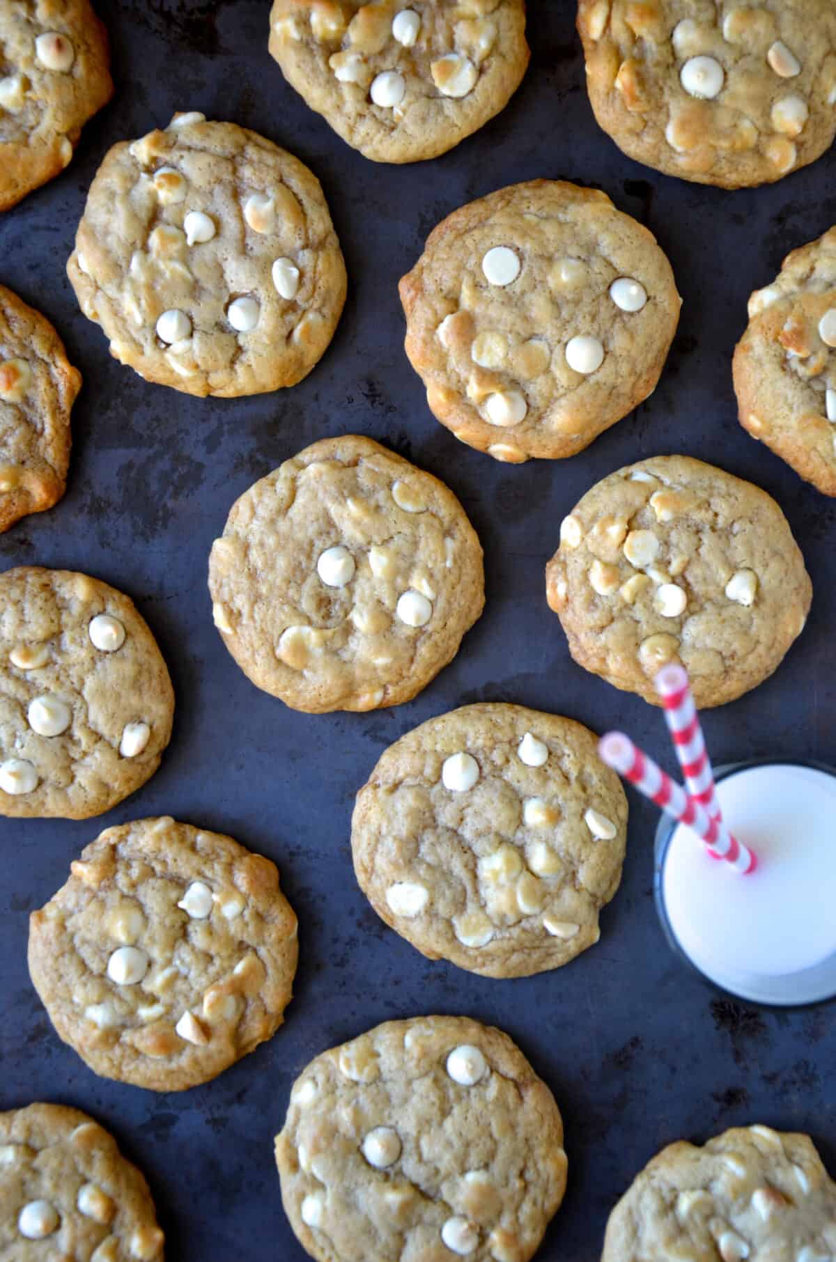 White chocolate cheesecake cookies next to a glass of milk.