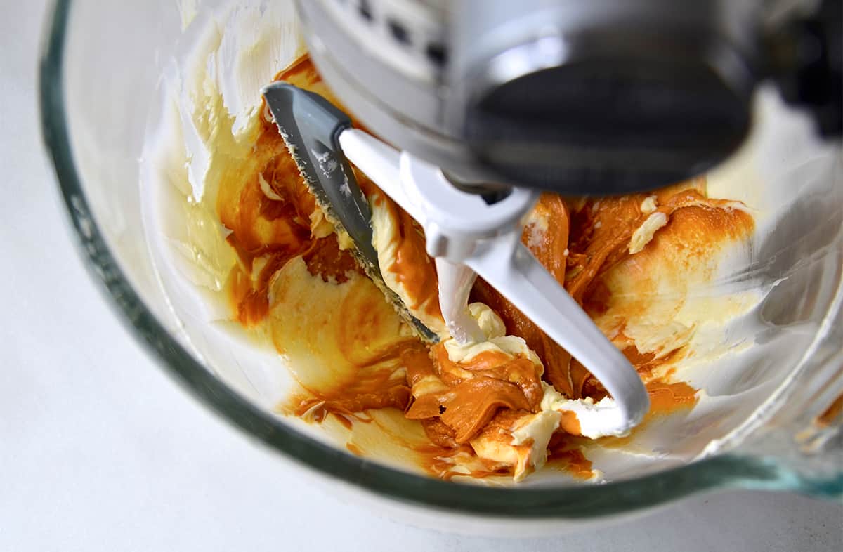 Melted butterscotch chips and whipped cream cheese in a bowl of a stand mixer with the paddle attachment.