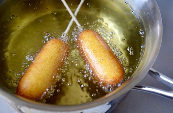 Heavy-bottomed stock pot with hot oil deep-frying mini corn dogs