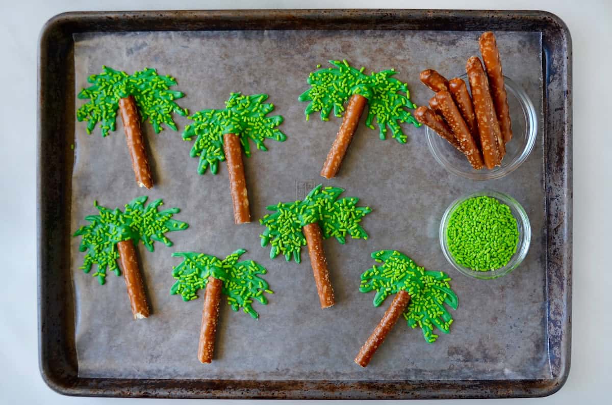 Palm tree cupcake toppers made with pretzel rods, green candy melts and green sprinkles.