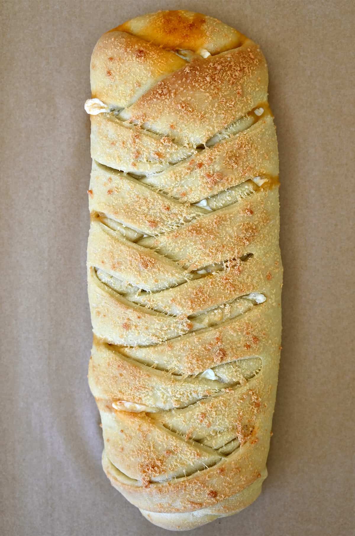 Golden brown Stromboli atop brown parchment paper.