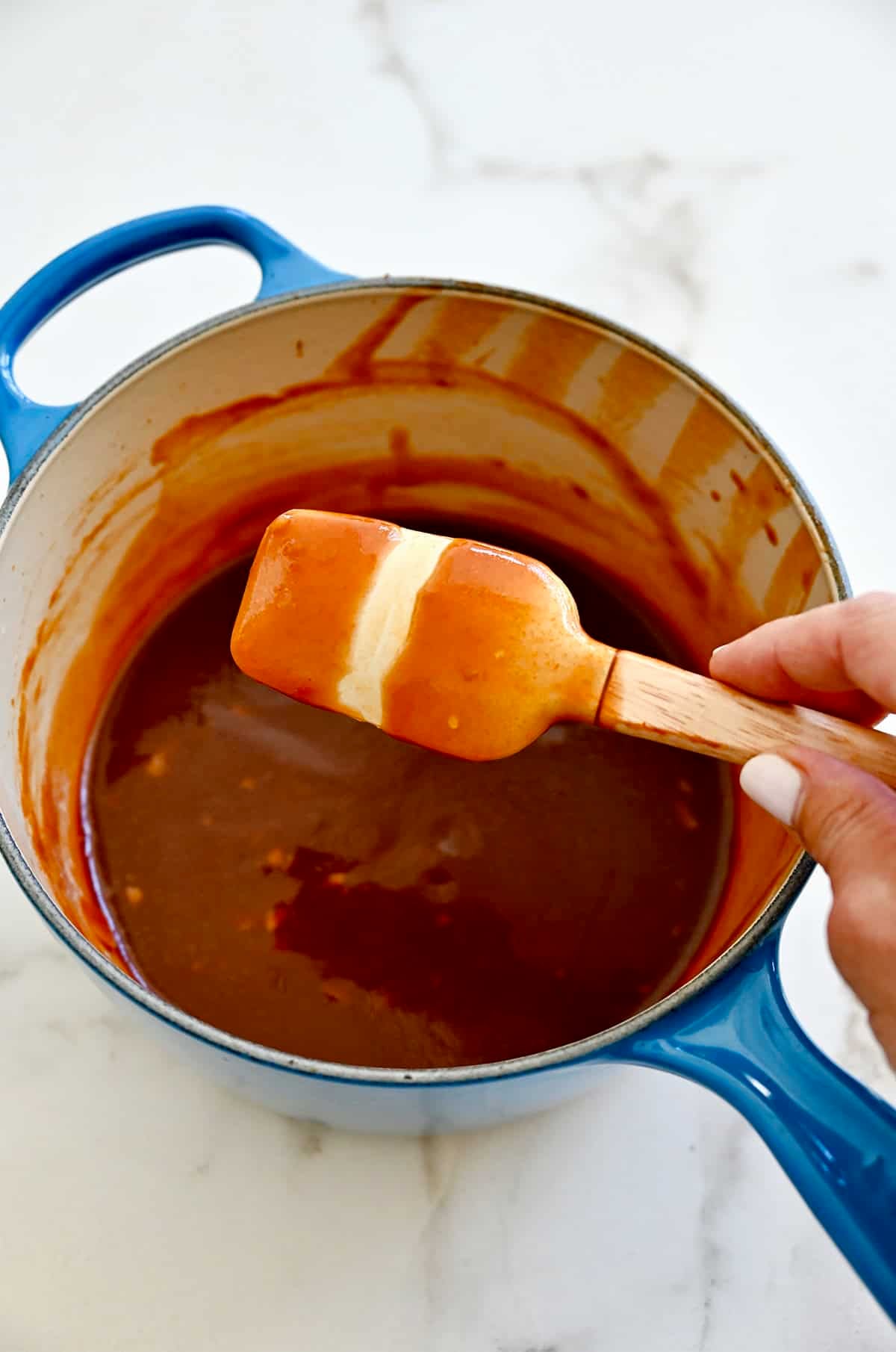 Thickened barbecue sauce coating a spatula.
