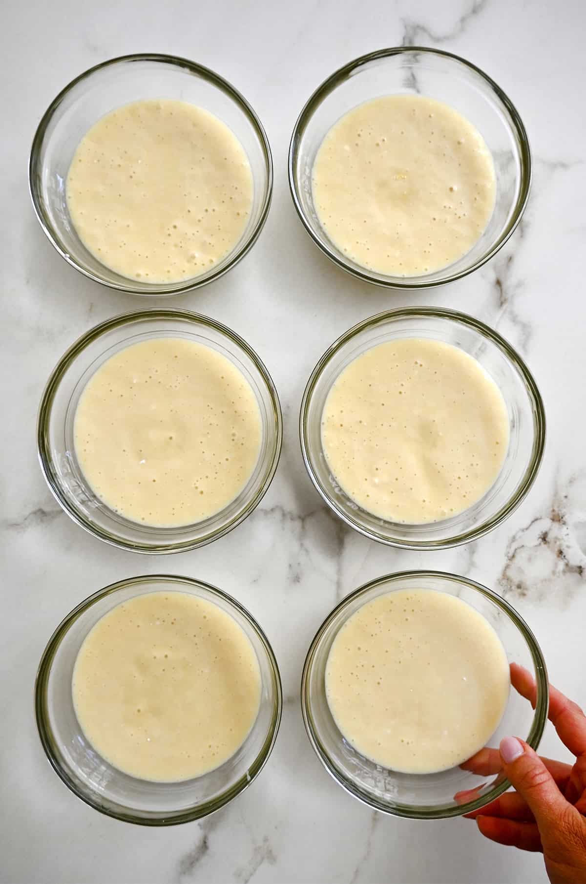 Six bowls containing cake batter.