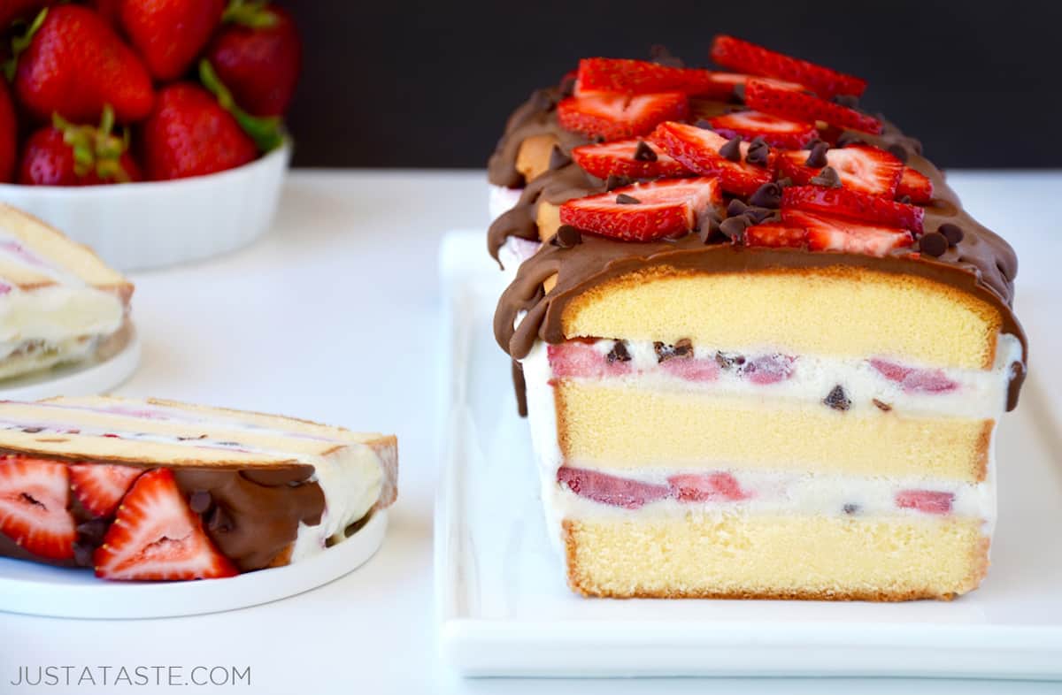A homemade ice cream cake with layers of pound cake, vanilla ice cream, sliced strawberries and mini chocolate chips.