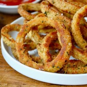 A white plate containing baked onion rings