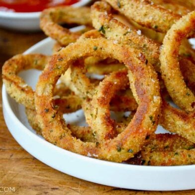 A white plate containing baked onion rings