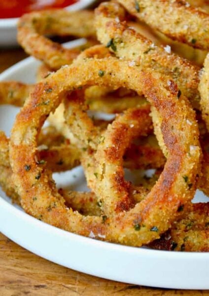 A white plate containing baked onion rings
