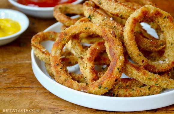 A white plate containing baked onion rings