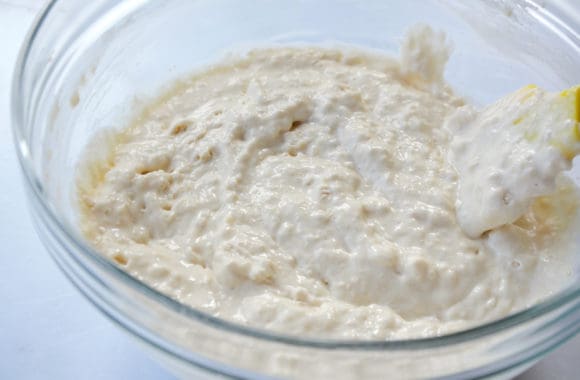 Glass bowl containing pancake batter and spatula