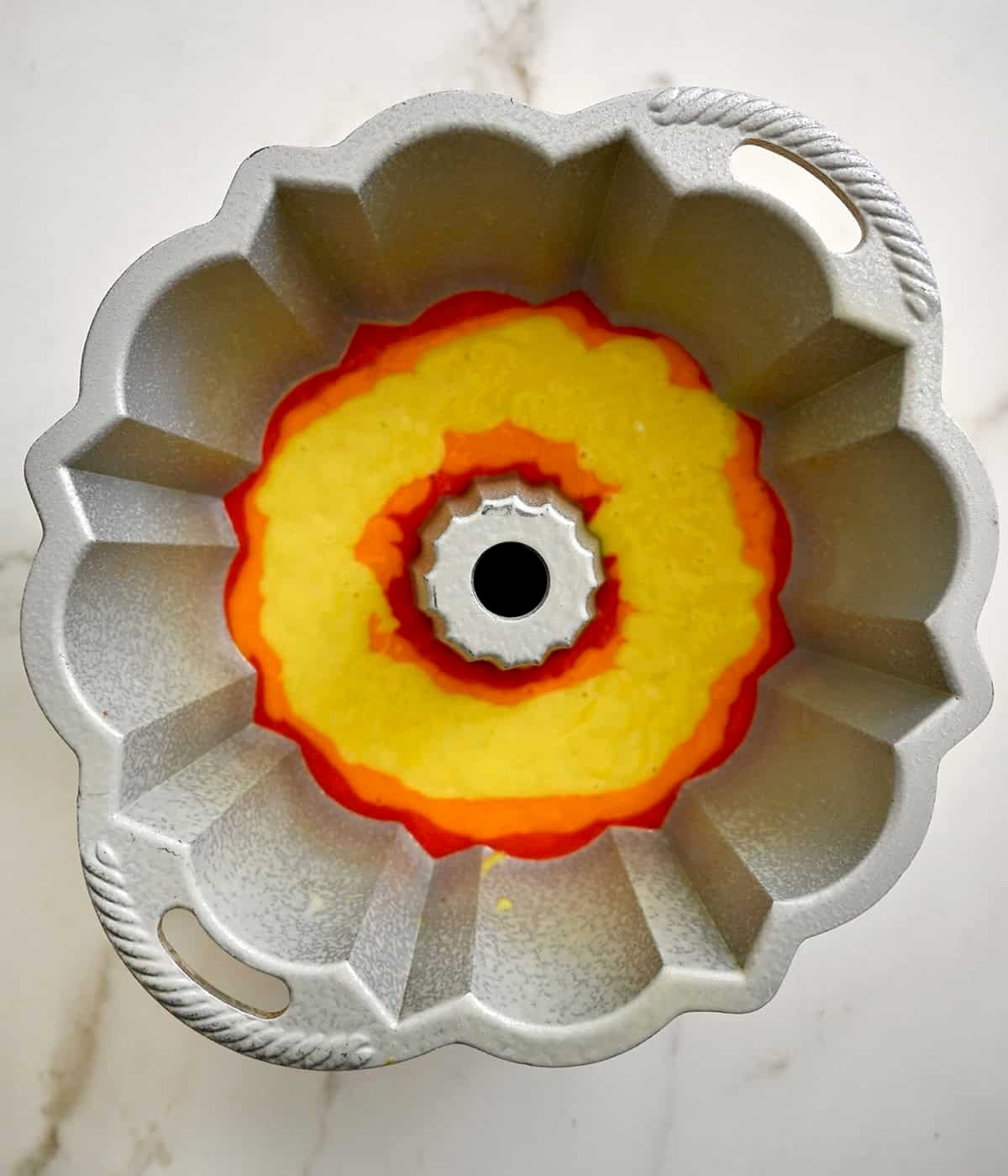 Yellow cake batter layer of a rainbow bundt cake.