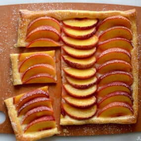 A top-down view of the best 5-ingredient peach tart on a wooden cutting board.