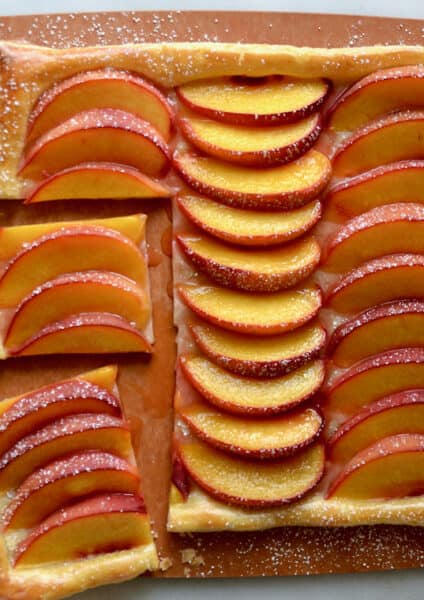 A top-down view of the best 5-ingredient peach tart on a wooden cutting board.