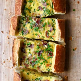 Cheesy baked egg boat with bacon garnished with fresh chopped chives.