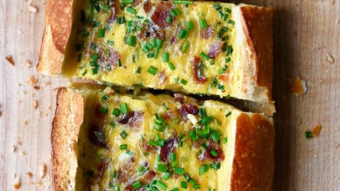 Cheesy baked egg boat with bacon garnished with fresh chopped chives.