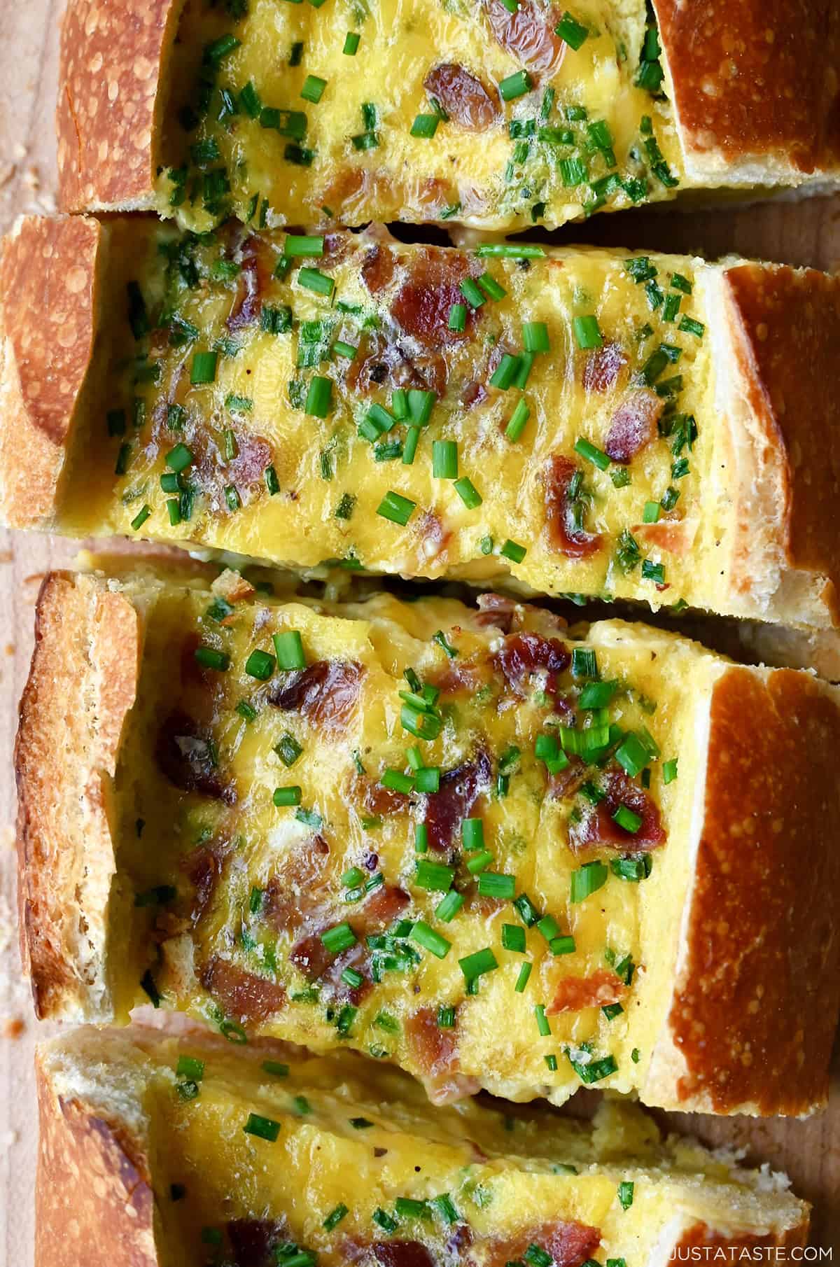 Baked scrambled eggs with cheddar cheese and bacon in a hallowed-out bread loaf.