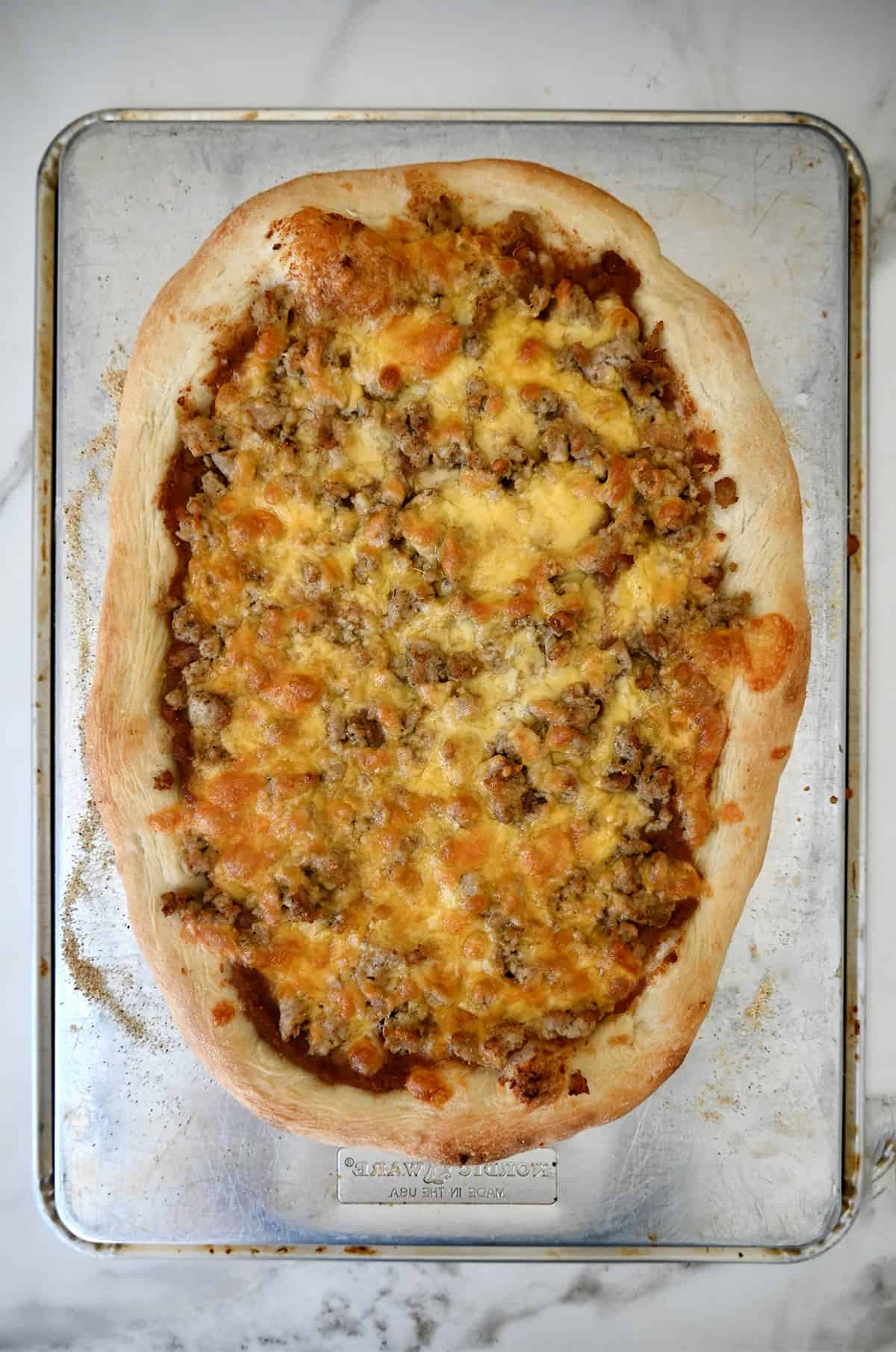 Freshly baked taco pizza without fresh toppings.