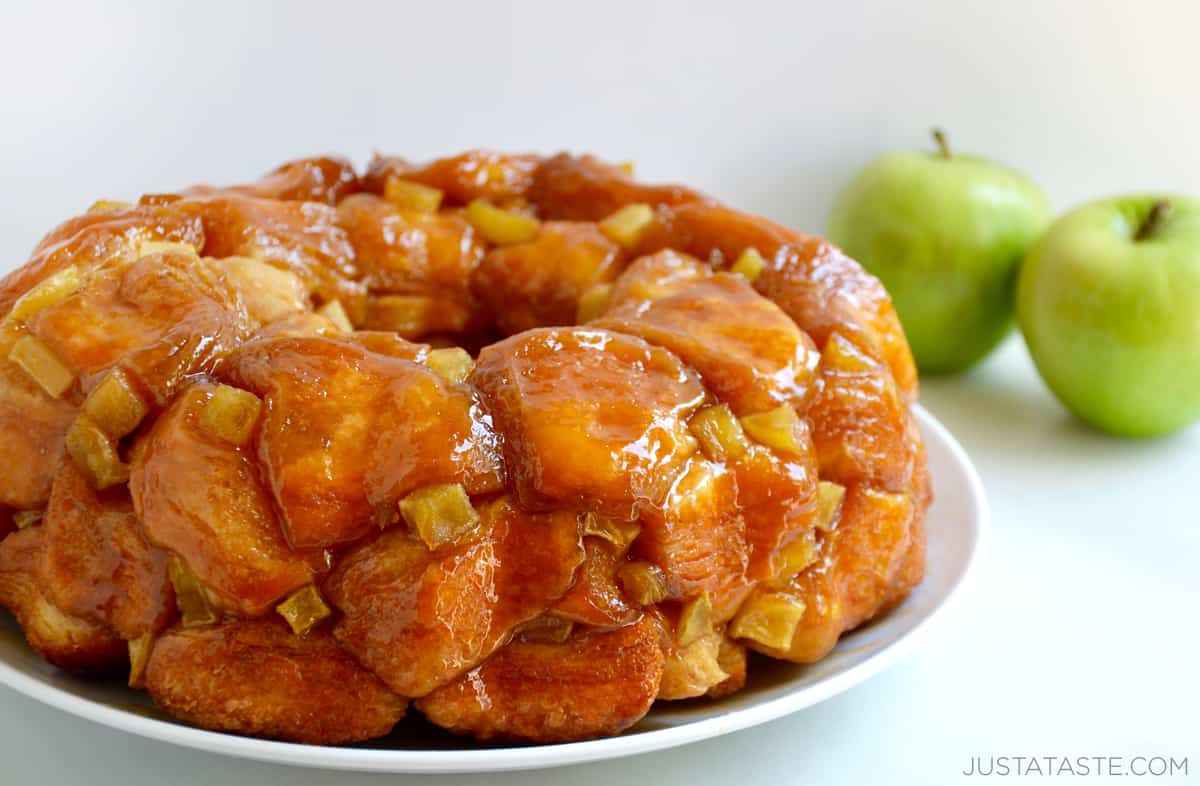 Caramel apple monkey bread with diced apples on a white serving plate.