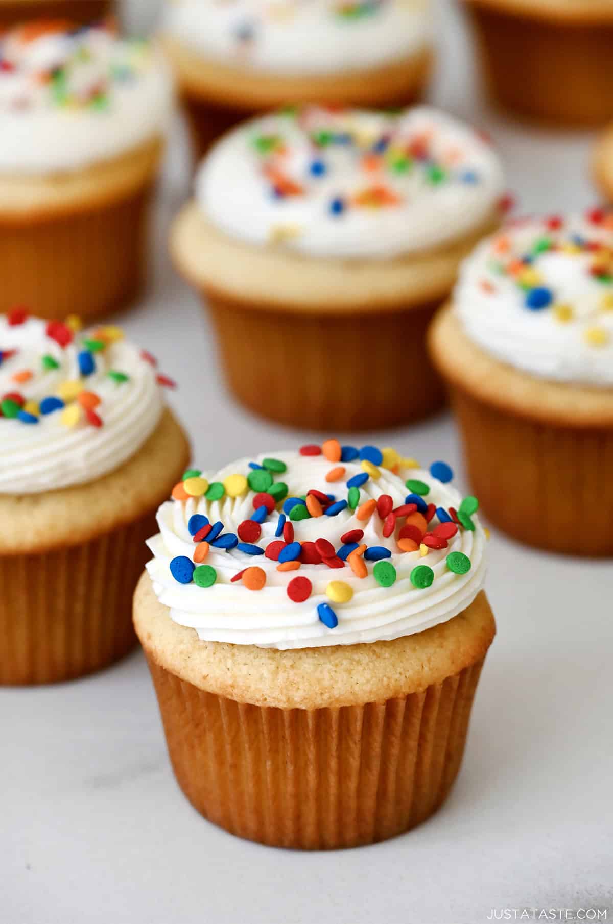 Fluffy vanilla buttercream frosting piped onto a cupcake and topped with confetti sprinkles.