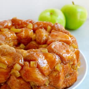 Caramel apple monkey bread with diced Granny Smith apples on a white serving plate.