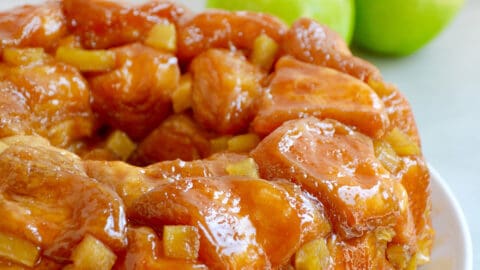 Caramel apple monkey bread with diced Granny Smith apples on a white serving plate.