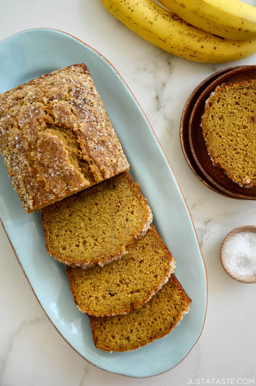 A half-sliced loaf of Pumpkin Banana Bread on a blue serving plate